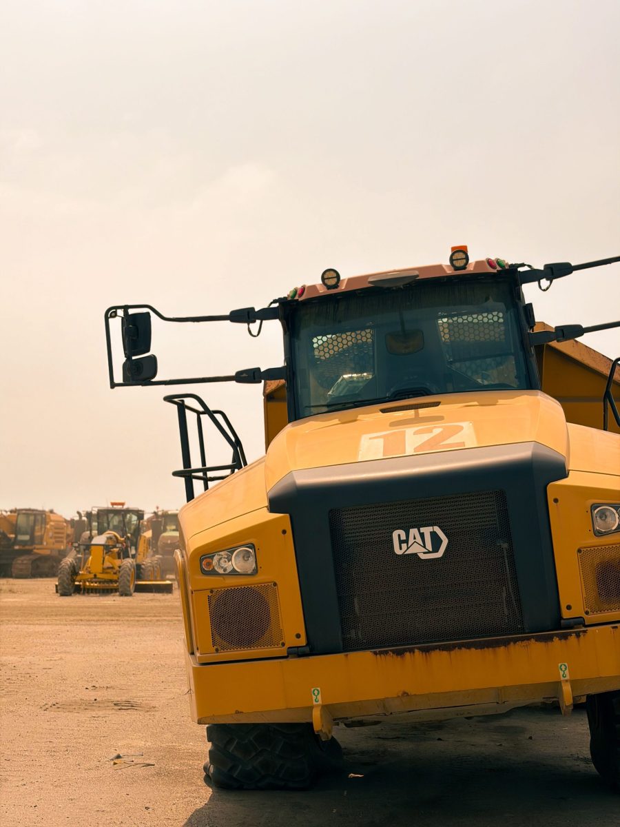 A dump truck on a sunny day at a construction site, showcasing its massive size and robust design.